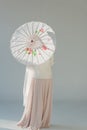 back view of attractive woman in fashionable winter outfit standing with japanese umbrella Royalty Free Stock Photo