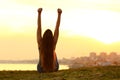 Excited woman raising arms watching the sunset on the city Royalty Free Stock Photo