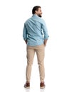 back view of bearded casual man holding hands in pockets and looking to side Royalty Free Stock Photo