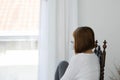 Back of view Beautiful Attractive Asian young woman sitting on wooden chair looking outside windows Royalty Free Stock Photo