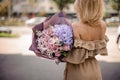 Back view of beautiful blonde woman in beige dress holding a rom Royalty Free Stock Photo