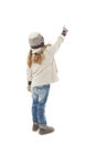 Back view of beautiful caucasian blonde fashionable girl in warm clothes pointing up. Winter style.