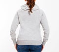 Back view : beautiful european mid aged woman dressed in a light grey casual hooded jacket - studio shot in front of a white Royalty Free Stock Photo