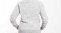 Back view : beautiful european mid aged woman dressed in a light grey casual hooded jacket - studio shot in front of a white Royalty Free Stock Photo