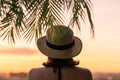 Back view of a beautiful girl in a straw hat against the background of the sea in branches of palm trees. Sunset beach. Summer Royalty Free Stock Photo