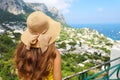 Back view of beautiful girl with straw hat looking at Capri sight from terrace, Capri Island, Italy Royalty Free Stock Photo