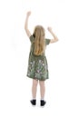Back view of beautiful little girl in dress looking at wall and holds hand up. young blonde girl standing. Rear view people. Royalty Free Stock Photo