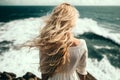 Back view beautiful slim girl with long flowing blond hair in the wind against the background of the sea and horizon. Generative