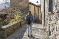 Back view of beautiful tourist woman walking in old medieval town of Rupit in Barcelona Spain.Traveling lifestyle concept