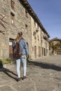 Back view of beautiful tourist woman walking in old medieval town of Rupit in Barcelona Spain.Back view vertical photography