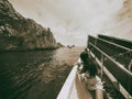 Back view of beautiful woman in a boat visiting Faraglioni in Capri