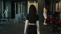 Back view from behind unrecognizable woman fitness trainer sportswoman girl going walking in sports club in modern gym Royalty Free Stock Photo