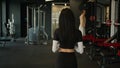 Back view from behind unrecognizable woman fitness trainer sportswoman girl going walking in sports club in modern gym Royalty Free Stock Photo