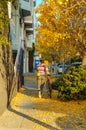 Back view of a biker on the street covered by gingko leaves.