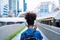 Back view of black student girl wearing headset and using mobile smartphone Royalty Free Stock Photo
