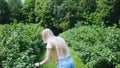 Back view of blonde young woman walking in natural park