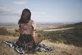 Back view of the Boho girl on a hill looking far in the distance Royalty Free Stock Photo