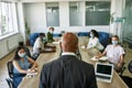 Back view of boss tell to employees at meeting