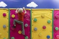 Back view on boy climbs soft climbing wall. Soft room for games. Child has fun in the childrens playroom