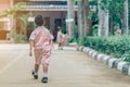 Back view of Boy followed girl friends on street to go to the classroom