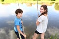 Back view of boy and girl on wooden pier with rod Royalty Free Stock Photo