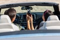 Back view of boyfriend and girlfriend cheering with coke bottles driving cabriolet Royalty Free Stock Photo