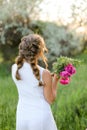 Back view bride walking with bouquet of pions and wearing white dress. Royalty Free Stock Photo