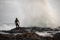 Back view brunette boy standing with a surf in his hands on the shore looking on the wave Royalty Free Stock Photo