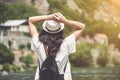 Rear view of brunette girl in park in straw hat.