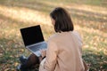 Back view of brunette woman working on laptop outdoors in the park Royalty Free Stock Photo