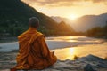 Back view of buddhist monk in meditation beside the river with beautiful nature background Royalty Free Stock Photo