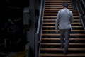 Business person walking up wooden staircase