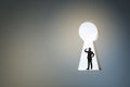 Back view of business man standing in abstract key hole opening in concrete wall with mock up place. Solution concept Royalty Free Stock Photo