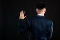 Back view of business man wearing blue business suit and tie taking oath Royalty Free Stock Photo