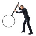 Back view of a businessman holding big magnifying glass in his outstretched arm isolated on white background