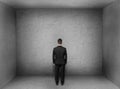 Back view of businessman inside empty concrete room