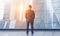 Rear view of businessman looking out of office window onto cityscape, collage. Panorama Royalty Free Stock Photo