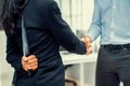 Back view of businesswoman shaking hands with a knife behind his back. Royalty Free Stock Photo