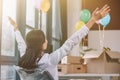 back view of businesswoman sitting on chair and raising hands in new office Royalty Free Stock Photo