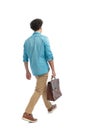 back view of casual curly hair man walking and holding suitcase Royalty Free Stock Photo