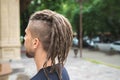 Back view of a caucasian man with dreadlocks and sidecut on a summer street Royalty Free Stock Photo