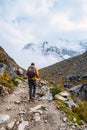 Back view of a caucasian man going uphill to the peak in a snowy mountain landscape