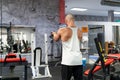 Back view of a caucasian young man doing biceps exercices in the gym, workout concept