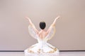 Back view of a charming ballerina is sitting on the floor in the ballroom warming up before the performance Royalty Free Stock Photo