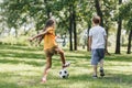 back view of children playing with soccer ball