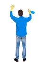 Back view of a cleaner man in gloves with sponge and detergent. Royalty Free Stock Photo