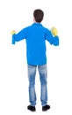 Back view of a cleaner man in gloves with sponge and detergent. Royalty Free Stock Photo