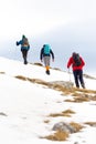 Back view of climbers climbing up a snowy hill