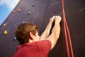 Back view close-up of climber hands on a rock hook of the artificial climbing wall outdoors. Young healthy sporty Royalty Free Stock Photo