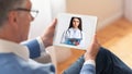 Man having video chat with doctor on tablet at home Royalty Free Stock Photo